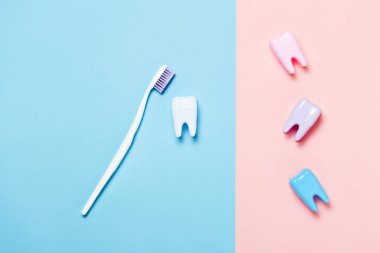 Diş fırçası ve mavi ve pembe arka plan üzerinde büyük diş. Diş Bakımı minimalizm kavramı.