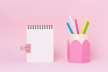 Pembe arka plan üzerinde boş defter ve kalemlik resmi mock up.