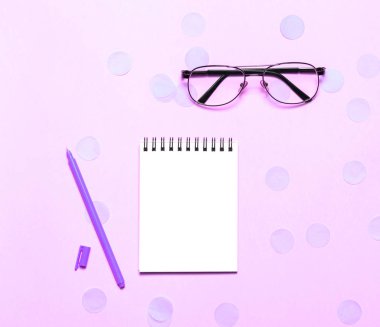 Pembe backgriund üzerinde gözlük ve kulaklık ile Dizüstü veya not defteri. Yaratıcı minimalizm şans kavramı. Üst görünüm, düz yatıyordu.