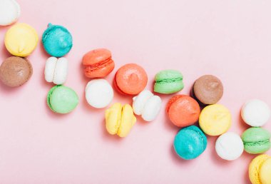 Tatlı metin eklemek için kopya alanı ile yumuşak pembe Kağıt arka plan üzerinde renkli mini macarons grubudur. Üstten görünüm, düz yatıyordu.