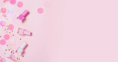 Pastel pembe tırnak cilaları ve konfeti, yıldız ve parıldıyor. Parlak ve festival arka plan. Manikür kavramı. Üstten görünüm, düz yatıyordu. metniniz için boşaltmak.