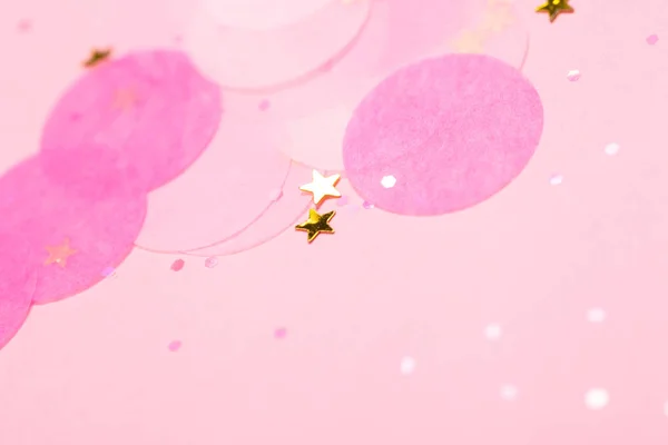 Confiti rosa y estrellas y destellos sobre fondo rosa . — Foto de Stock
