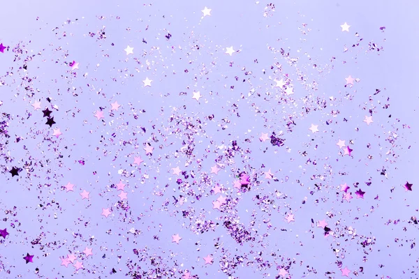 Confettis violets et étoiles violettes et scintille sur fond violet . — Photo