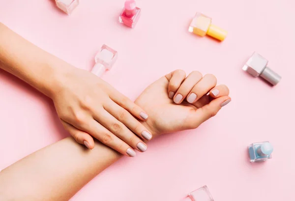 Hermosas manos femeninas con manicura elegante de moda sobre fondo rosa . — Foto de Stock