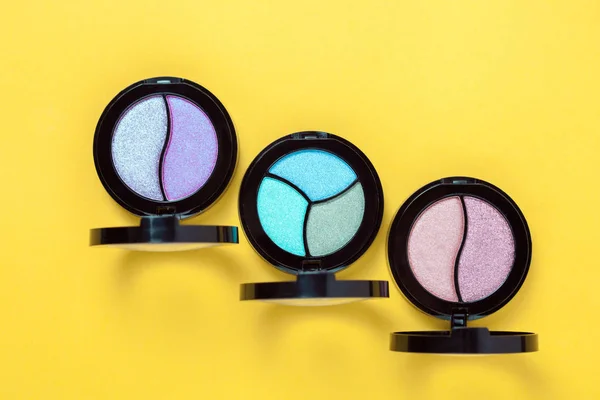Three Eye shadows pallets and applicators on yellow background. — Stock Photo, Image