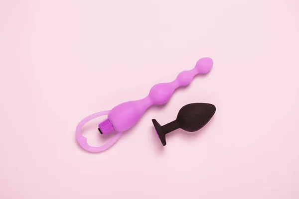 Konfeti ile pembe arka plan yetişkin seksi oyuncak anal fiş. Üst görünüm, düz yatıyordu.