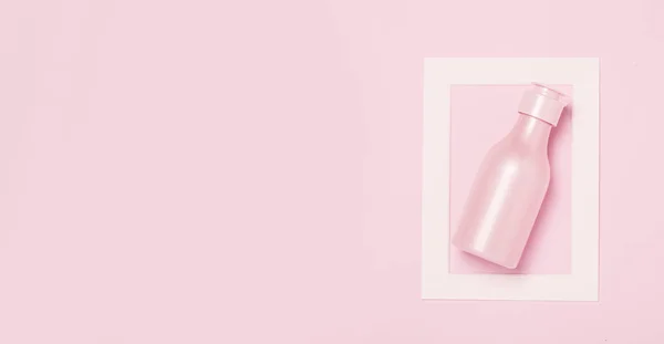 Креативний мінімальний фон краси та здоров'я з рожевою пляшкою — стокове фото