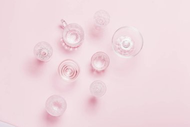 Pembe arka planda birçok boş bardak. Üst görünüm, düz yatıyordu.