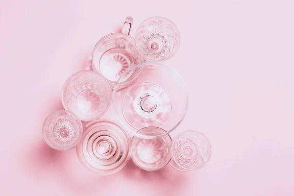 Muchos vasos vacíos sobre fondo rosa. Vista superior, plano . —  Fotos de Stock