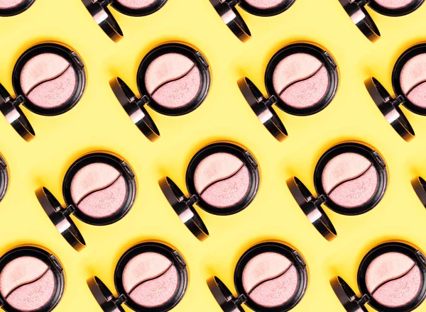 Paletas de tres sombras de ojos y varios pinceles de maquillaje sobre fondo amarillo . — Foto de Stock