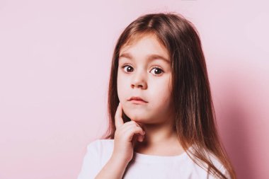 Pembe arka plan üzerinde küçük şüphe kız Komik portre.