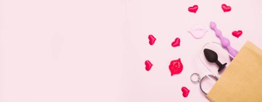 Pembe arka planda yetişkin seks oyuncakları ve aksesuarları.