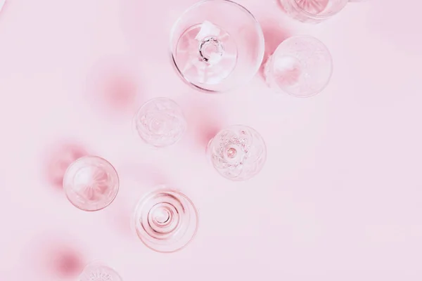 Many empty glasses on pink background. Top view, flat lay. — Stock Photo, Image