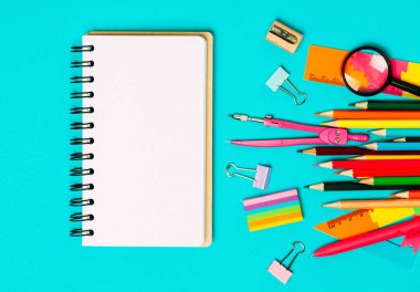 Okul aksesuarları ve ofis kırtasiye ve yeşil arka plan üzerinde emty notrbook.