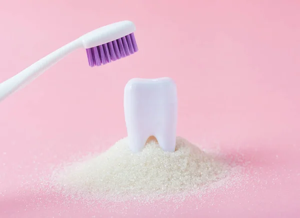 Plastic tooth in big pile of sugar. — Stock Photo, Image