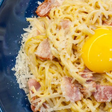 Mavi bir tabakta carbonara ezmesi. Ulusal İtalyan yemeği.