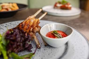 Domates soslu kuzu kaburgası ve taze yeşillik..