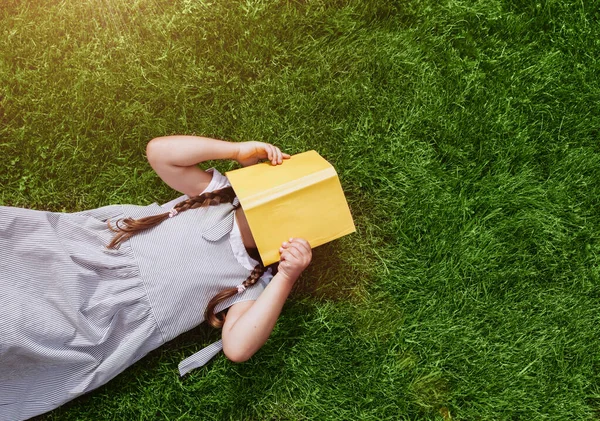 Schattig Schoolmeisje Met Vlechtjes Gras Terwijl Het Boek Leest Onderwijs Stockfoto