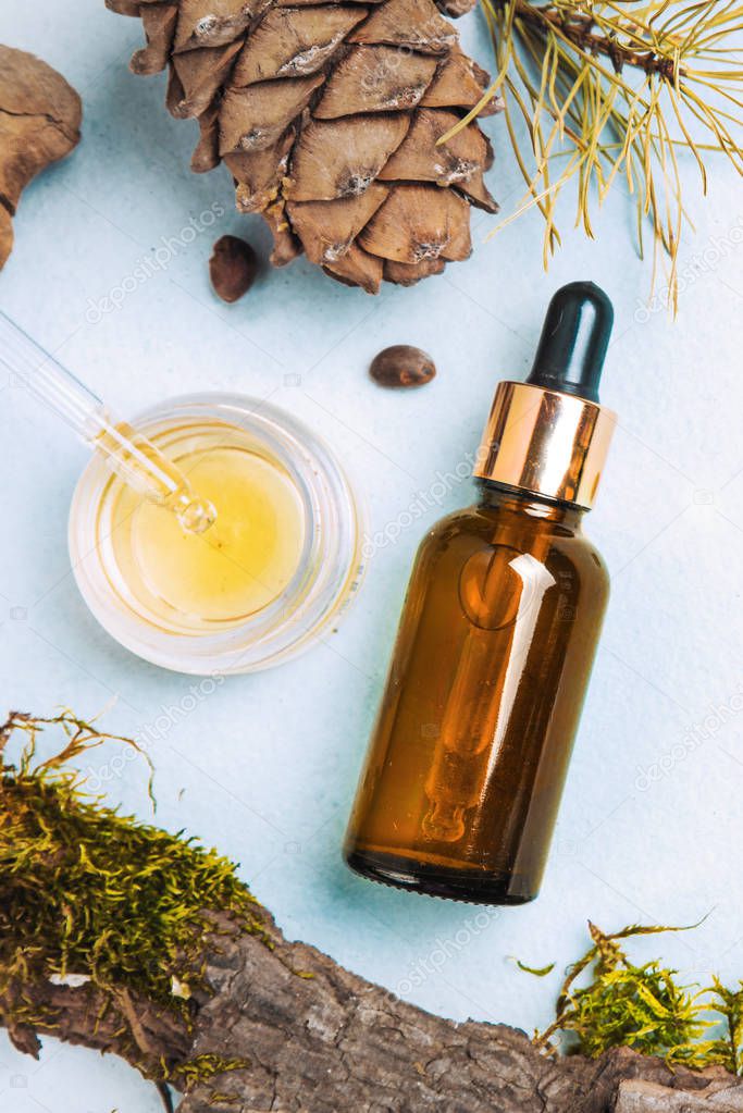 Cedar essential oil, pine in a glass brown glass bottle with a pipette. Flat lay, minimalism The concept of natural cosmetics