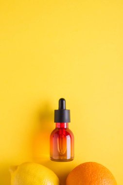 Cam şişe ve turuncu sarı bir arka plan üzerinde. C vitamini ile organik bio kozmetik Minimalizm düz kavramı yatıyordu.