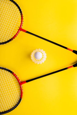 Volant ve raket, badminton sarı zemin üzerine. Yaz eğlence kavramı. Pop Art minimalizm