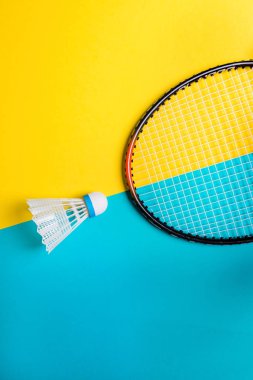 Volant ve sarı zemin üzerine badminton oynamak için raket. Yaz eğlence kavramı. Minimalizm Pop Art