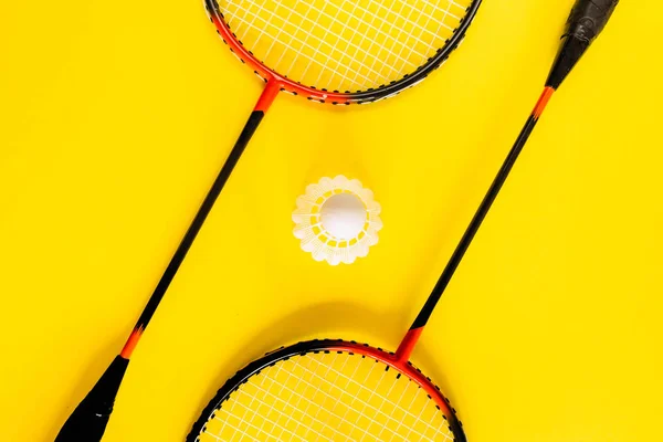 Volant と、黄色の背景にバドミントンのラケット。コンセプト興奮、抵抗、競争。ポップアート ミニマリズム — ストック写真