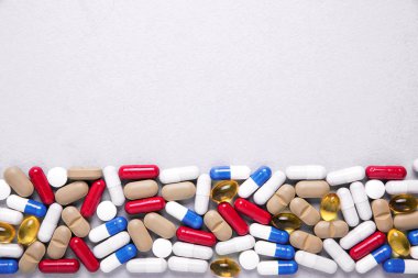Eczacılık preparatları, arka plan. Renkli ilaçlar hap, tablet ve kapsüller dağılmış. Tıp kavramı.