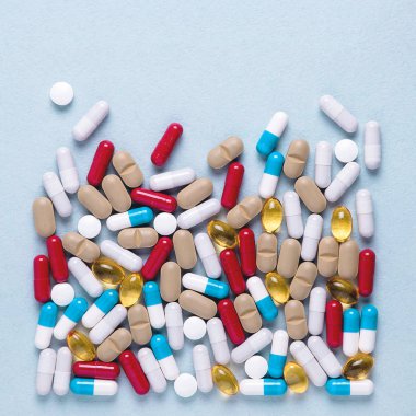 Eczacılık preparatları, arka plan. Renkli ilaçlar hap, tablet ve kapsüller dağılmış. Tıp kavramı.