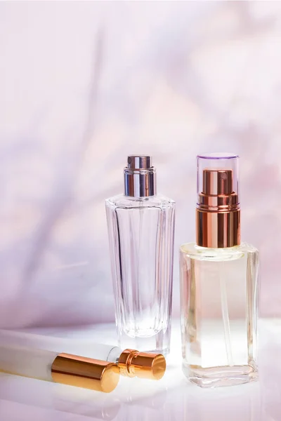 Bottiglia di profumo su uno sfondo floreale rosa chiaro. Concentrazione selettiva. Collezione di profumi, cosmetici — Foto Stock