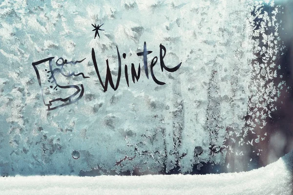 Nápis zimní a brusle na zamrzlé okno — Stock fotografie