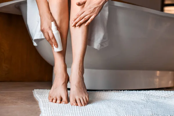 Body care. Young woman in the bathroom, stroking her legs. Anti-cellulite treatment for beautiful well-groomed legs — Stock Photo, Image