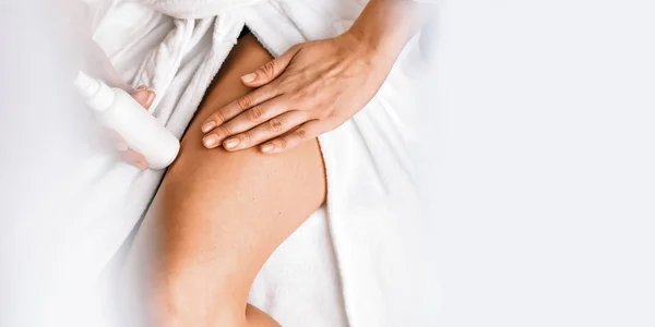 Body care. A young woman in the bathroom applies natural cream to her legs. Against varicose veins and leg edema Banner — Stock Photo, Image