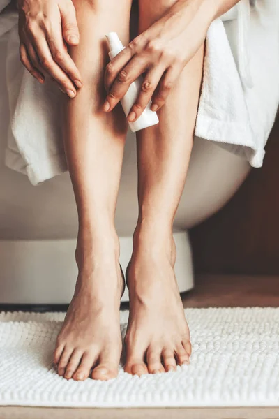 Female legs. Young woman in the bathroom, stroking her legs. — Stock Photo, Image