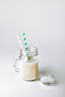 Protein ile vanilya ve toz beyaz zemin üzerine bir bardak
