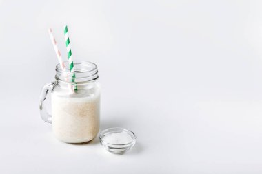 Protein shake süt cam ve hafif bir arka plan üzerinde kuru protein tozu