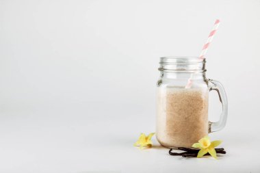Protein sütlü kokteyl, vanilya bir cam kavanoz payet ile. Spor ve beslenme