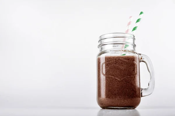 Batido de proteínas, batido con chocolate y cacao en un frasco sobre un fondo blanco — Foto de Stock