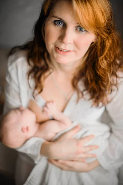母乳喂养。红头发美丽的母亲母乳喂养一个新生儿。自然外观照片 — 图库照片