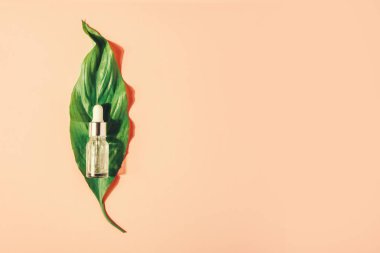 Pembe bir arka planda vitamin ile doğal serum ile şişe. Yüz için kozmetik prosedürler