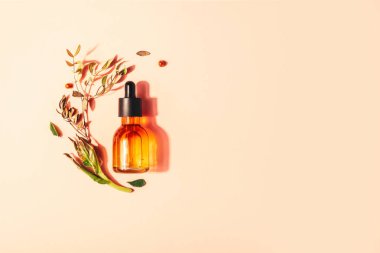 Pembe bir arka planda vitamin ile doğal serum ile şişe. Yüz için kozmetik prosedürler