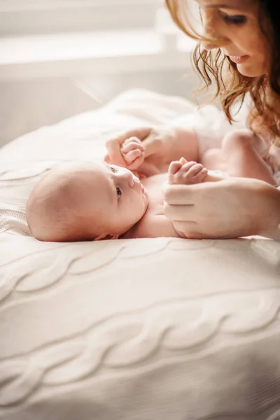 Genç bir anne yeni doğmuş bir bebeğe değer bilip onlarla oynar.. — Stok fotoğraf