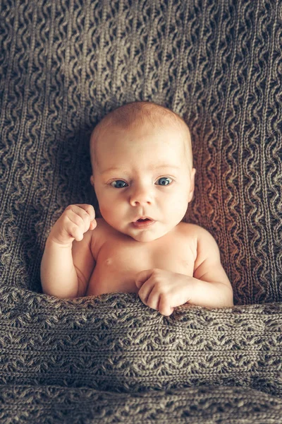 Divertido retrato de un recién nacido de rostro completo, acostado en una cuna, levantado a mano. Votación, elecciones —  Fotos de Stock