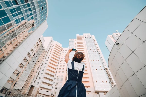 Bir kız yeni bir konut kompleksi Beyaz modern gökdelenler fotoğraf çekiyor.