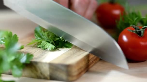 Vrouw is snijden peterselie, Groenen mes op houten plank. — Stockvideo