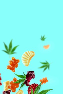 Renkli sakızlar kenevir yaprakları ile birlikte sinek. CbD yağı ile çiğneme şekerleri, Thc. Yaratıcı arka plan, minimalizm.