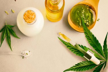 Cam şişe ve damlalık Cbd Yağı, Thc tentür ve arka planda kenevir yaprağı. Cbd yağı ile kozmetik üretimi.