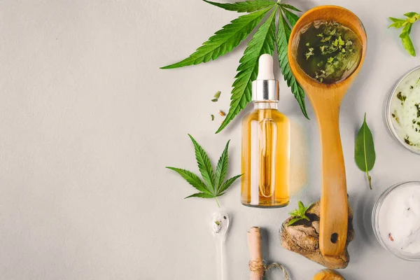 Glas flaska och Dropper CBD olja, THC tinktur och cannabisblad på bakgrunden. Tillverkning av kosmetika med CBD-olja. — Stockfoto