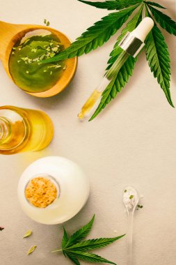 Cam şişe ve damlalık Cbd Yağı, Thc tentür ve arka planda esrar yaprağı