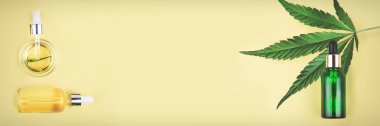 Cbd Yağı, Thc tentür ve esrar sarı arka plan üzerinde yaprakları ile farklı cam şişeler. Düz kozmetik Cbd yağı yatıyordu.